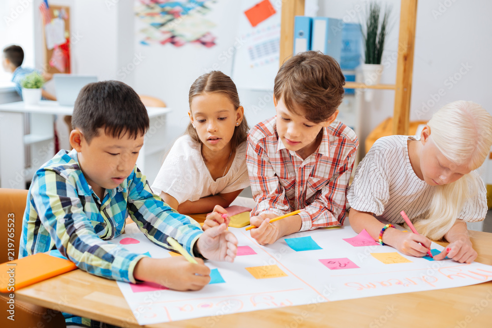 Hometask. Hardworking responsible kids preparing an extra task while being at school Hometask. Hardworking responsible kids preparing an extra task while being at school