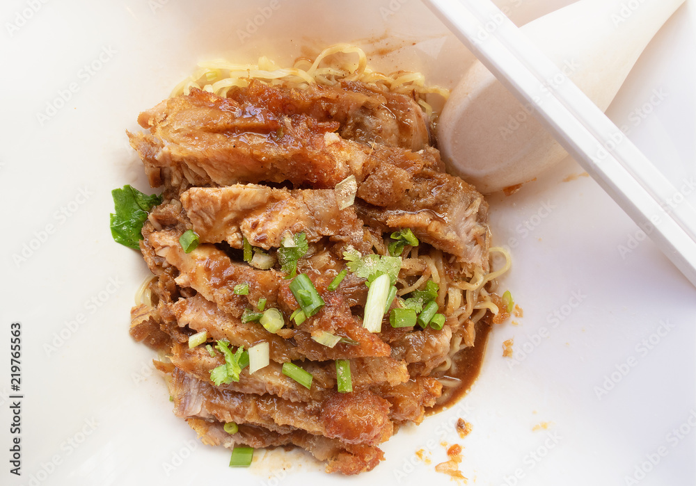 grilled pork roast with yellow or chinese noodle in white a bowl, street food concept grilled pork roast with yellow or chinese noodle in white a bowl, street food concept
