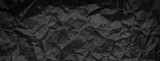 Ragged crumpled dark black paper texture background