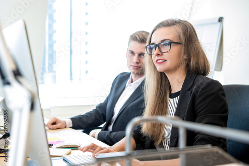 Businesswoman working on computer at the office with coworker