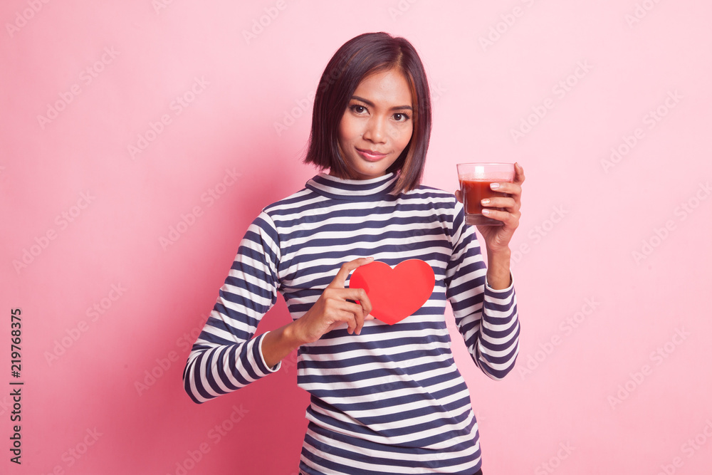 Young Asian woman with tomato juice and red heart. Young Asian woman with tomato juice and red heart.