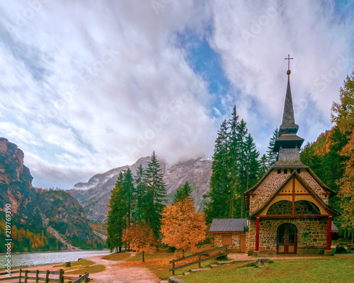 Amazing autumn scenery of small chapel at Lago di Braies Lake, Dolomite Alps, South Tyrol, Italy
