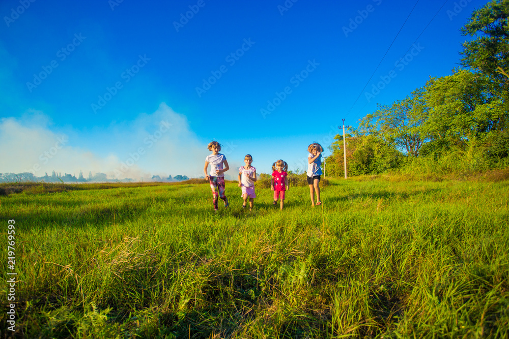 Group of happy kids running in green summer field Group of happy kids running in green summer field