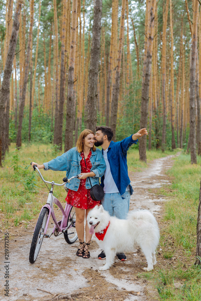 Fototapeta premium Bike together. Bearded husband feeling happy while kissing his woman riding bike in the forest together