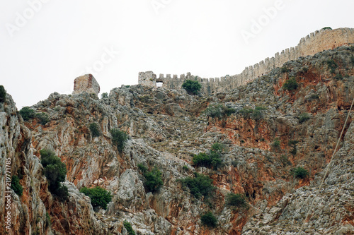 Rocky mountains and an ancient fortress on top .