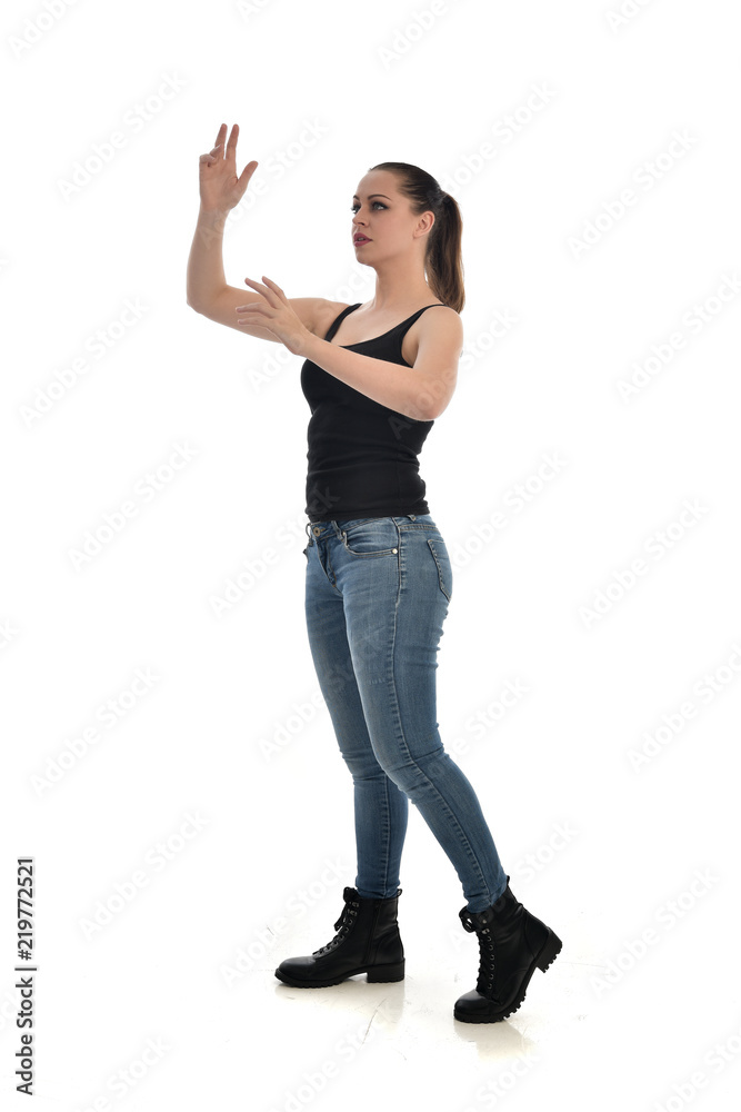 full length portrait of brunette girl wearing black single and jeans. standing pose facing the camera. isolated on white studio background. full length portrait of brunette girl wearing black single and jeans. standing pose facing the camera. isolated on white studio background.