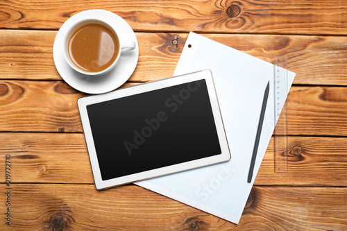 digital tablet and coffee cup on wooden table