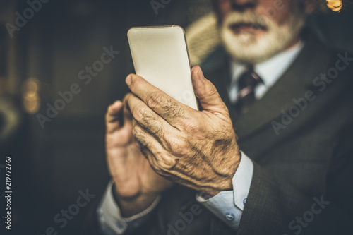 Senior businessman using mobile phone. Close up image. photo