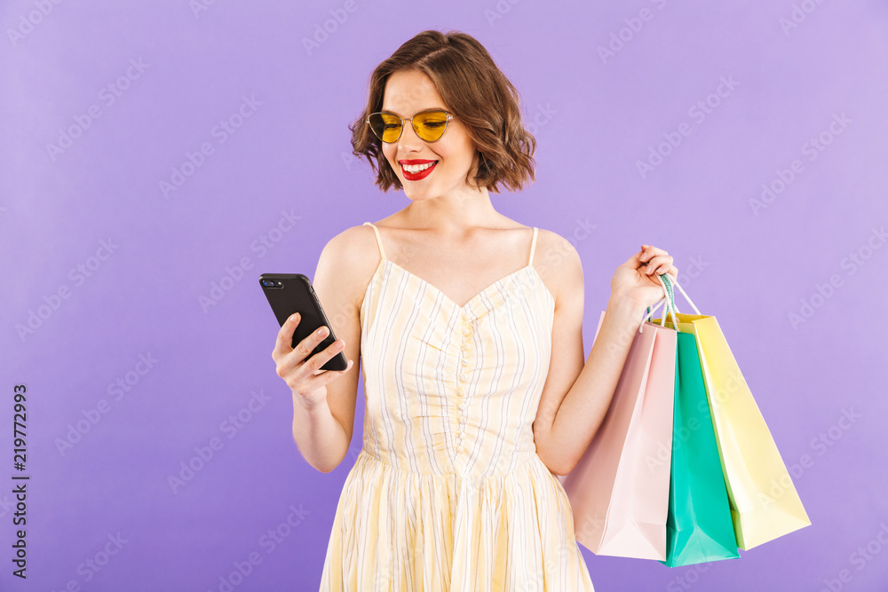 Young woman using mobile phone isolated over purple wall background. Young woman using mobile phone isolated over purple wall background.