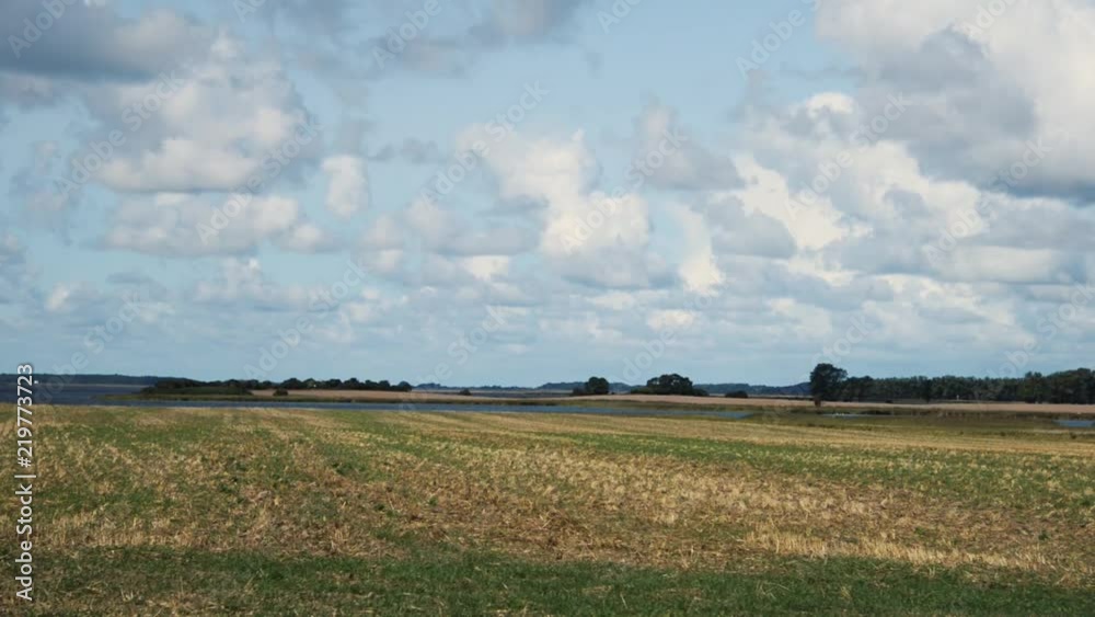 wide flat landscape. Clouds are moving in the sky, a quiet scene on a stubble field with horizon