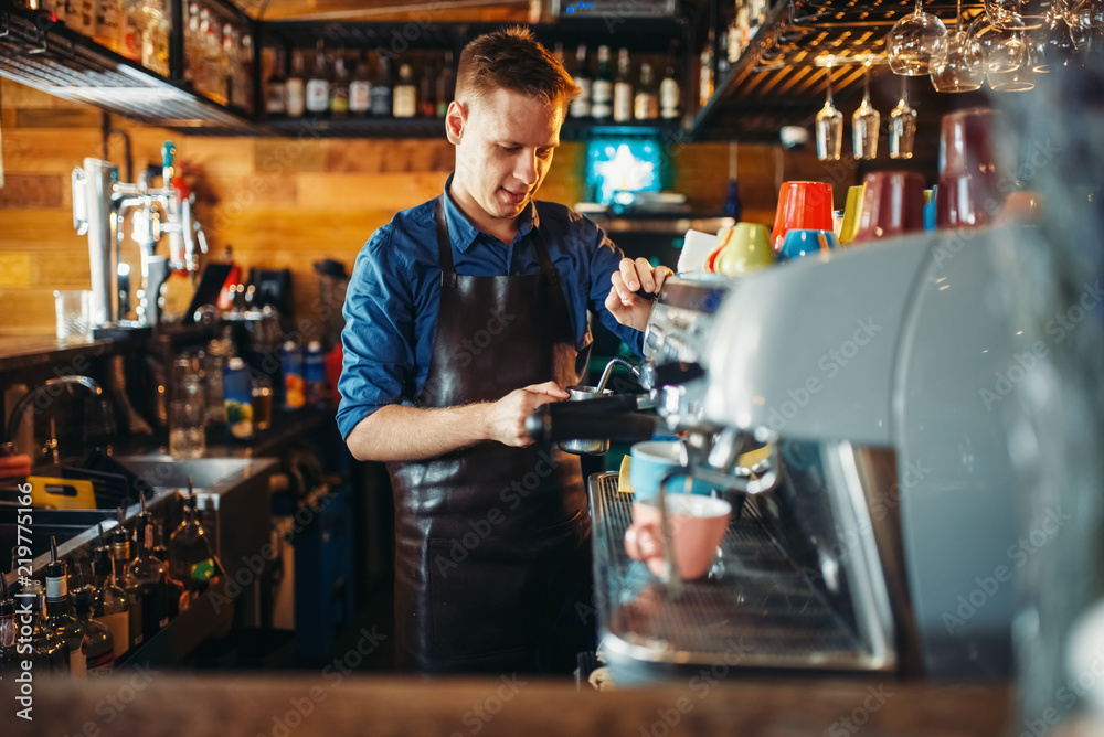 Male bartender prepares drink at the bar counter