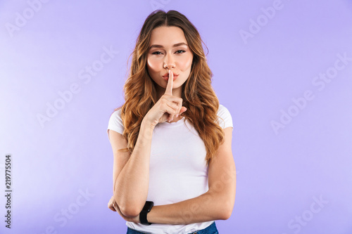 Woman isolated over purple wall background showing silence gesture.