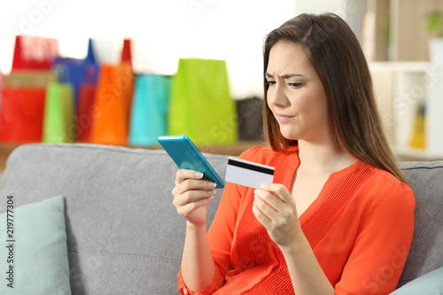 Confused woman paying online with a credit card