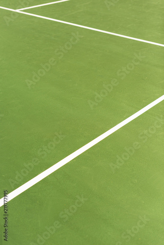close up view of green tennis court with white lines background