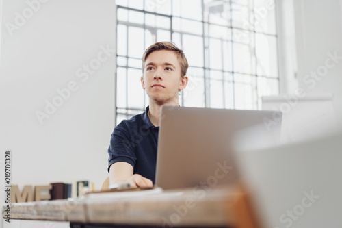 Thoughtful young businessman sitting watching photo
