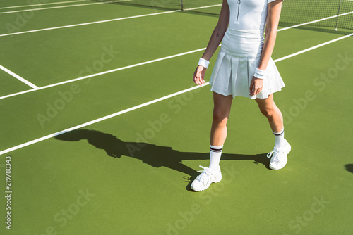 cropped shot of female tennis player in white sportswear walking on tennis court © LIGHTFIELD STUDIOS