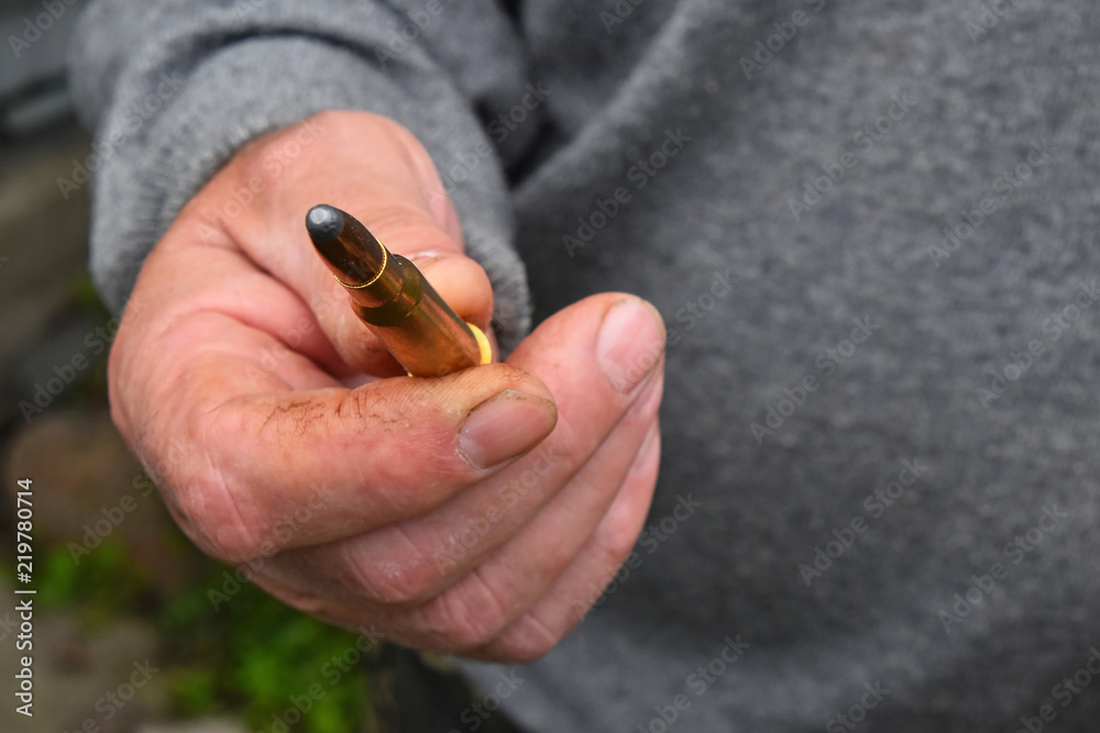 Man hand showing 7.62 caliber ammunition bullet