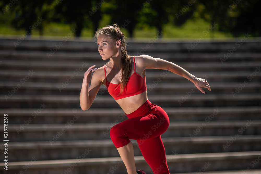 Young fitness woman running at the stadium. The concept of a healthy lifestyle