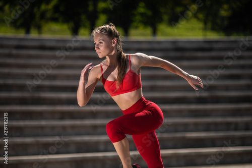 Fototapeta Naklejka Na Ścianę i Meble -  Young fitness woman running at the stadium. The concept of a healthy lifestyle