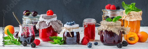 Assortment of seasonal berries and fruits jams in jars photo