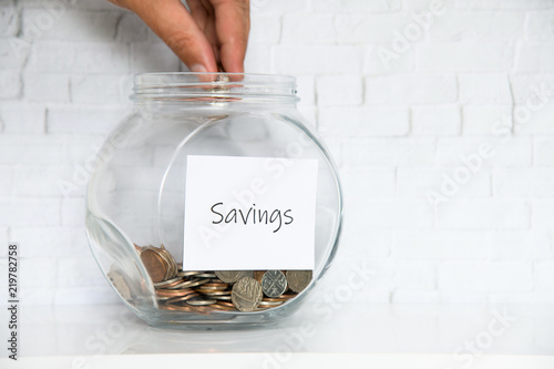 UK Money Jar on a white shelf in a household living room. Currency saving Concept photo