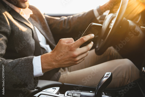Cropped image of careless bussinesman in suit driving photo