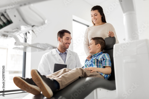 medicine  dentistry and healthcare concept - mother and son visiting dentist at dental clinic
