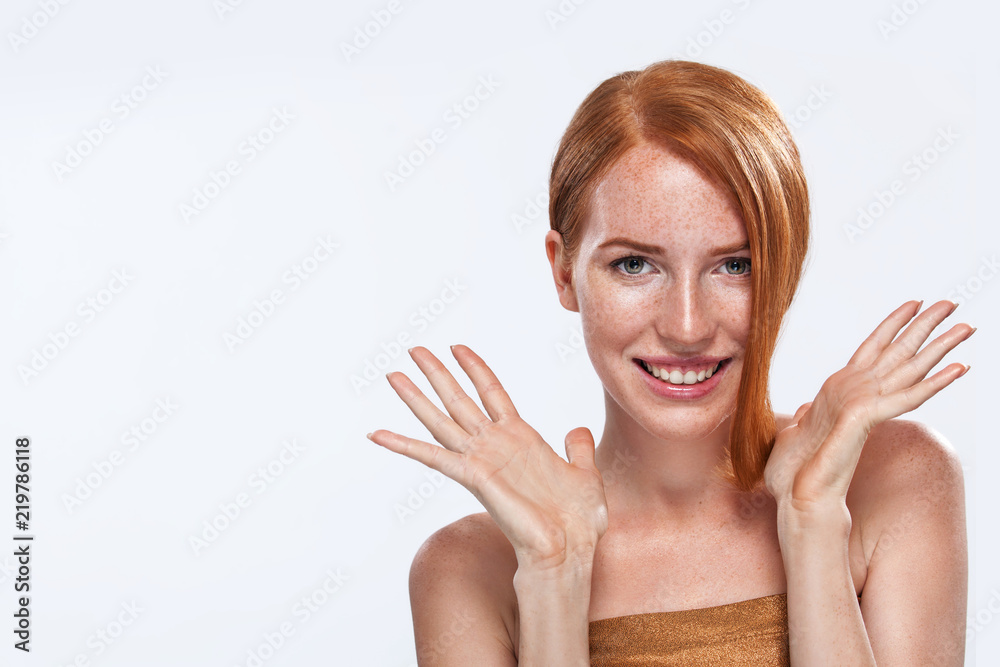 Red head girl with long and shiny wavy hair. Beauty. Beautiful model woman with curly ginger hairstyle and frackles.