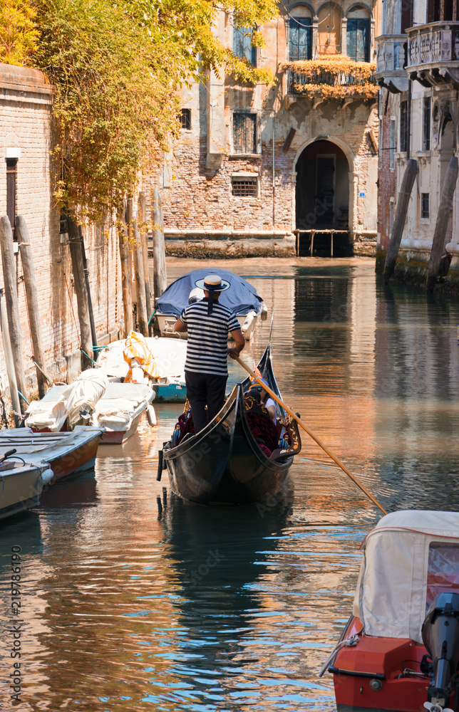 Gondola sails in a canal in autumn day in Venice