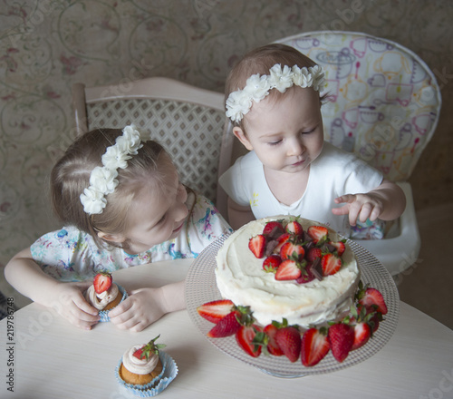 Obraz na plátne children celebrate a birthday with a strawberry cake