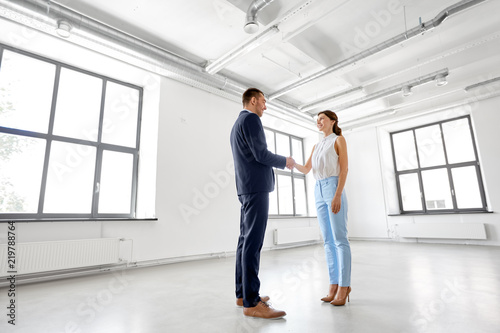 business people, partnership and cooperation concept - happy smiling businesswoman and businessman shaking hands at office © Syda Productions