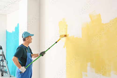 Male painter in uniform wor...