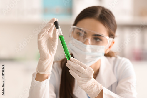 Female scientist holding test tube with color sample in laboratory