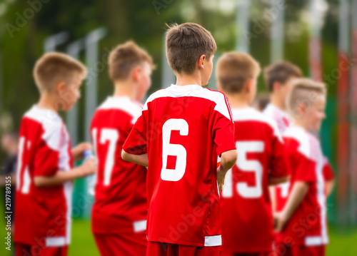 Boys football team together. Young football soccer players in jersey red sportswear