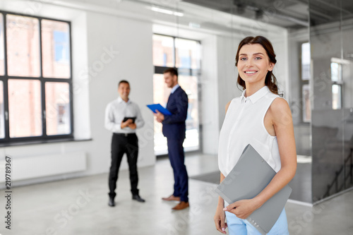 real estate business, sale and people concept - happy smiling realtor or businesswoman with folder and customers at new office room photo