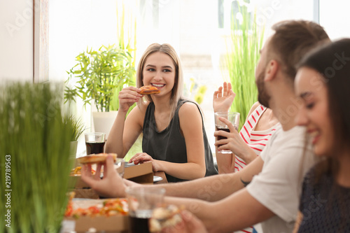 Young people eating pizza a...