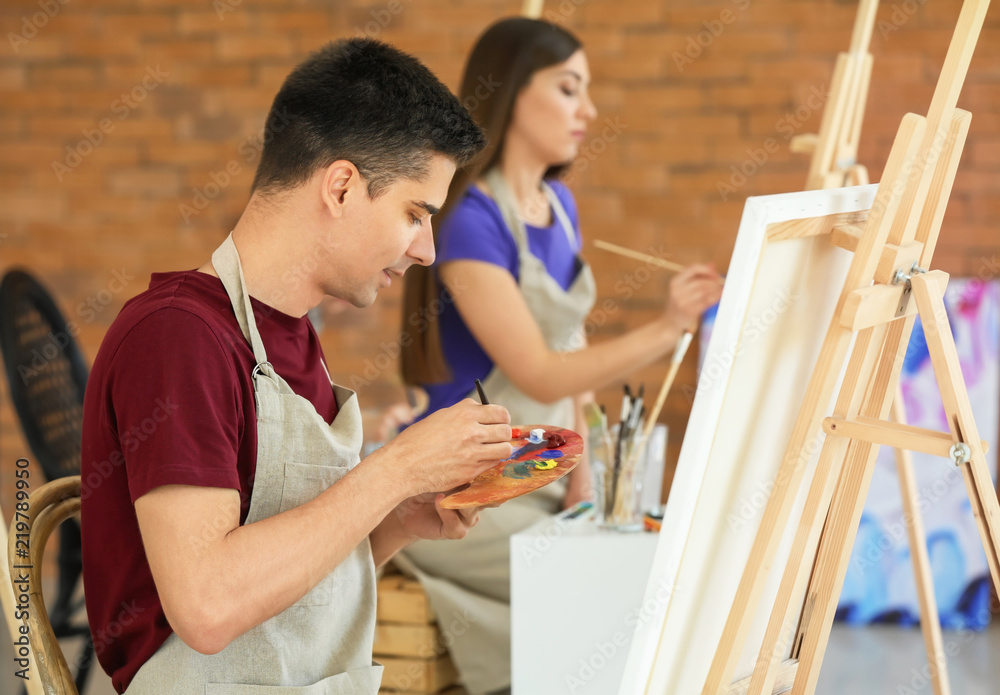 Male student during during classes in school of painters Male student during during classes in school of painters