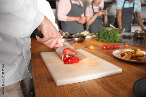 Male chef cutting vegetable...