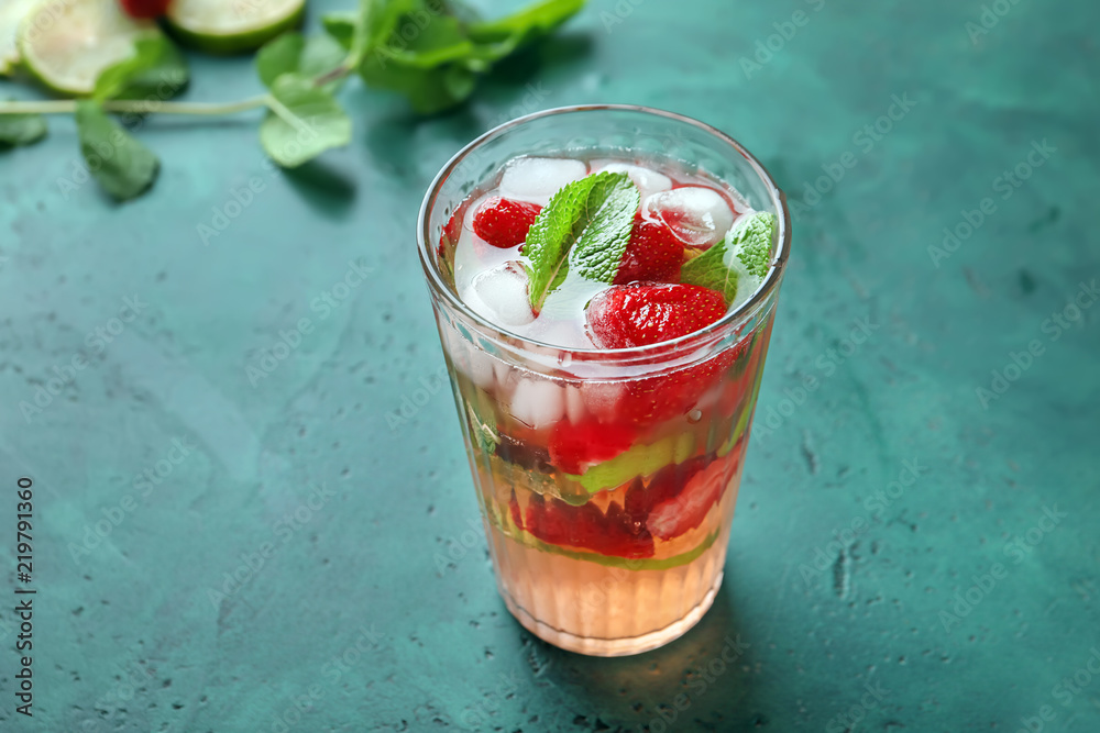 Glass with strawberry mojito on table
