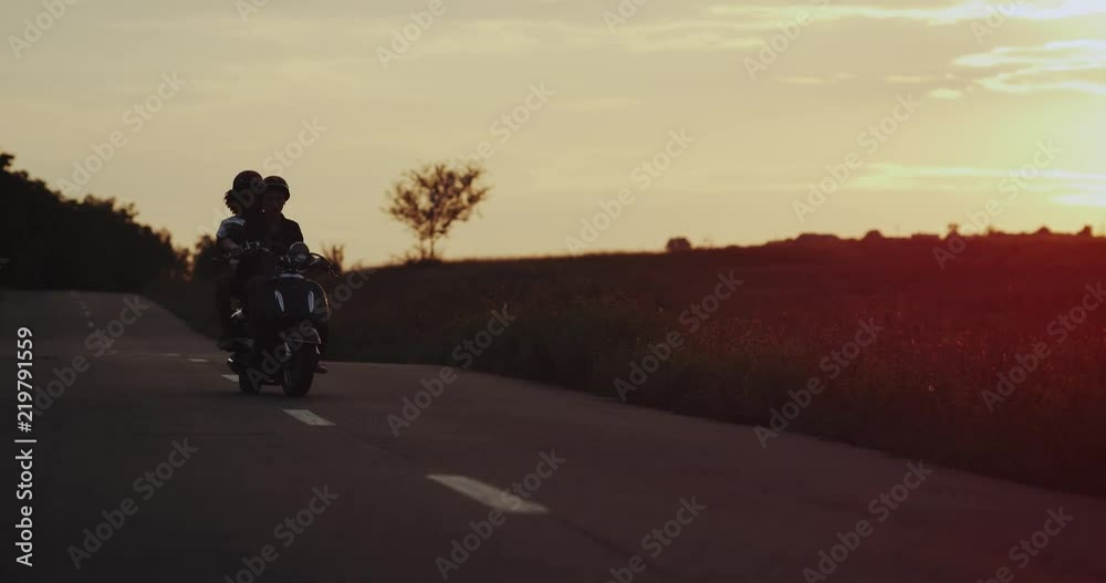 Young couple have a ride with amazing retro motorcycle on the road with amazing sunset. slow motions