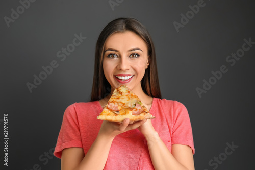 Young woman eating slice of...