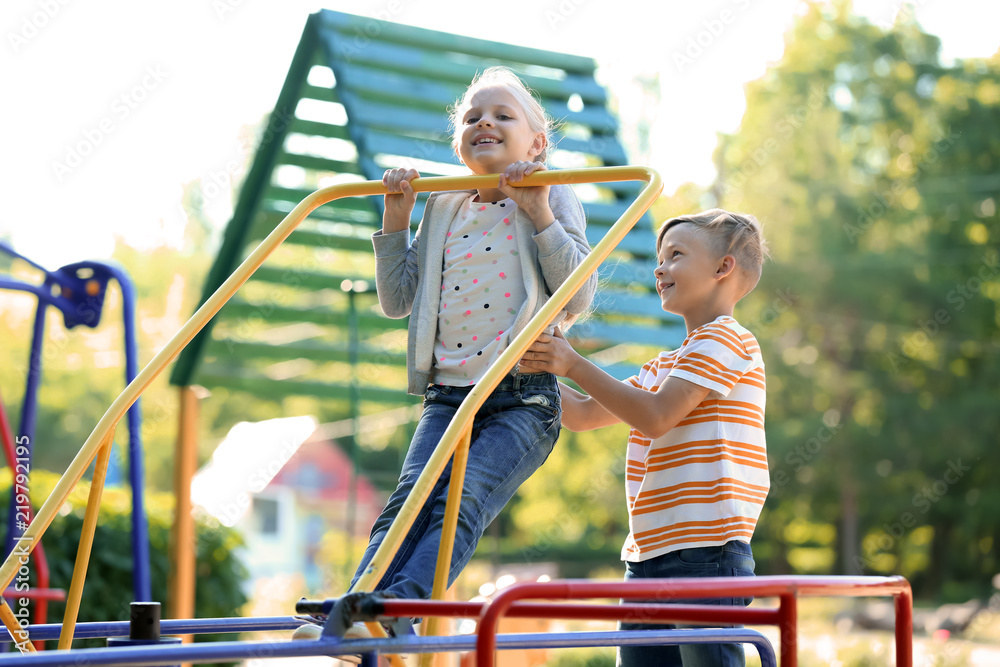 Cute little children having fun outdoors on playground