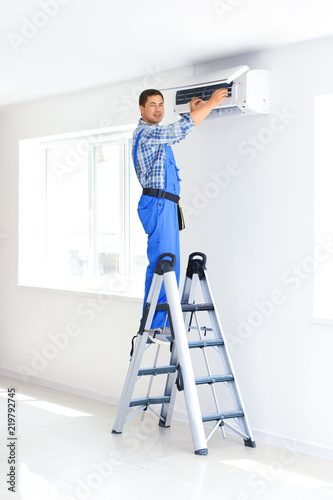 Electrician repairing air c...