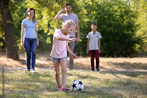 Happy family playing footba...