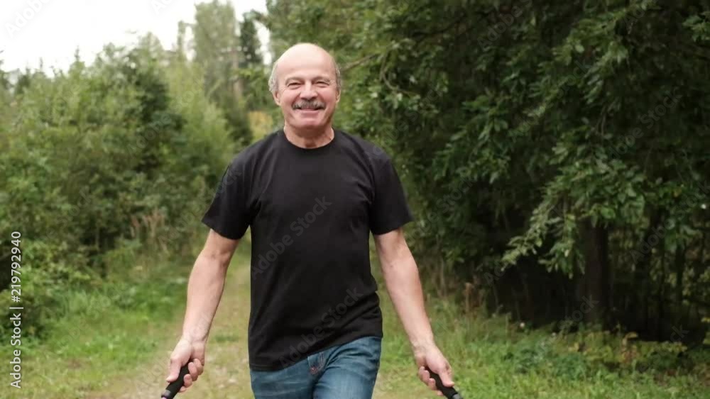 Close up shot of senior man skipping fancily with a jump rope on fresh air