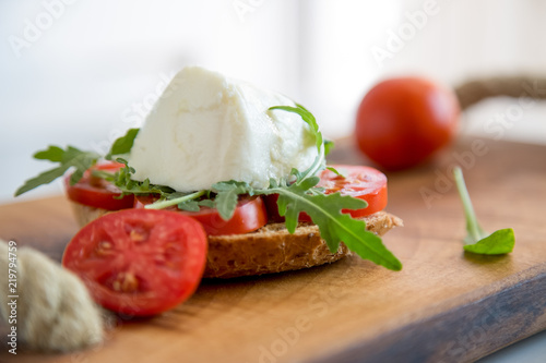 Italian style toast with light bread, arugula, tomato and mozzarella cheese 