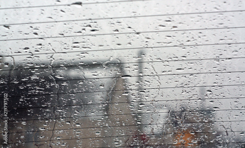 View through car rear window in rain drops with blur effect.