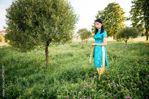 Asian woman with Chinese traditional dress cheongsam and holding Chinese fan. photo