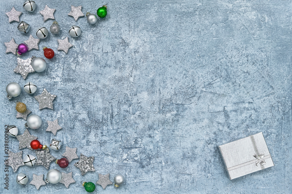 Christmas greeting card. Gift box and Christmas decoration on blue background. Top view, copy space.