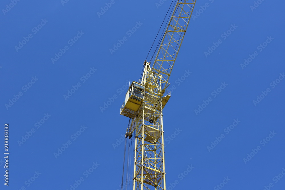 Yellow tower crane, blue sky background. Yellow tower crane, blue sky background.